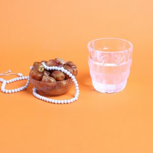 A bowl of dates, a cup of water and prayer beads